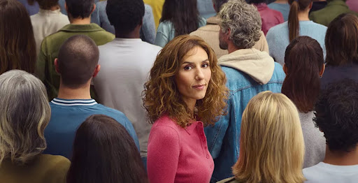 Photo d'une femme regardant l'objectif au milieu d'une foule de dos