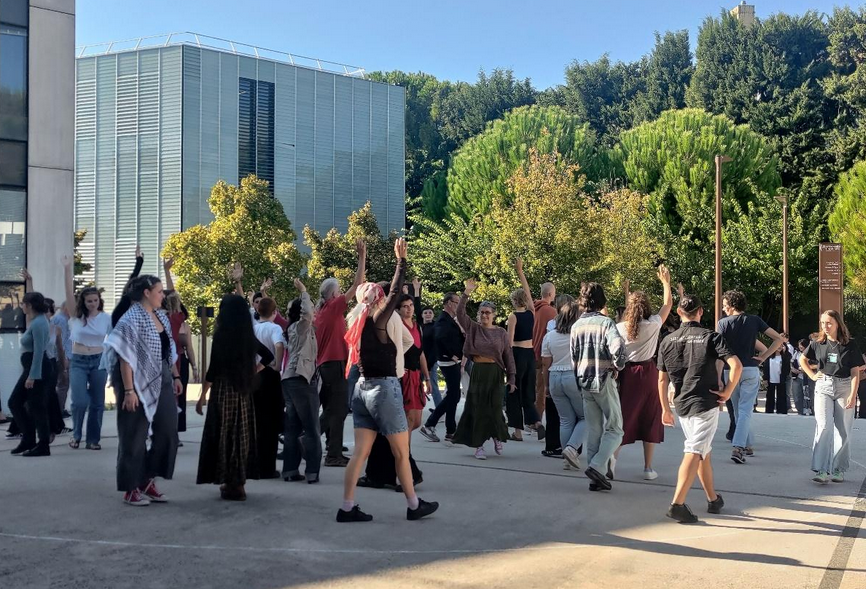 Des étudiants dansent sur le parvis du Cube